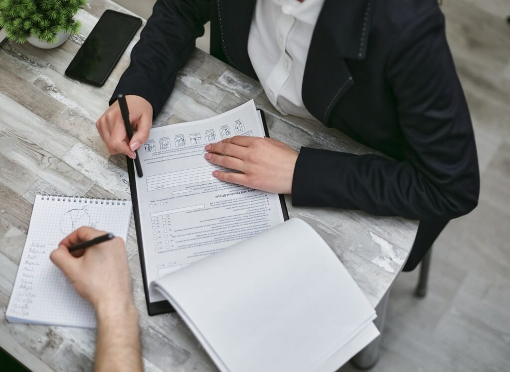 Two people carefully reviewing documents together at a desk