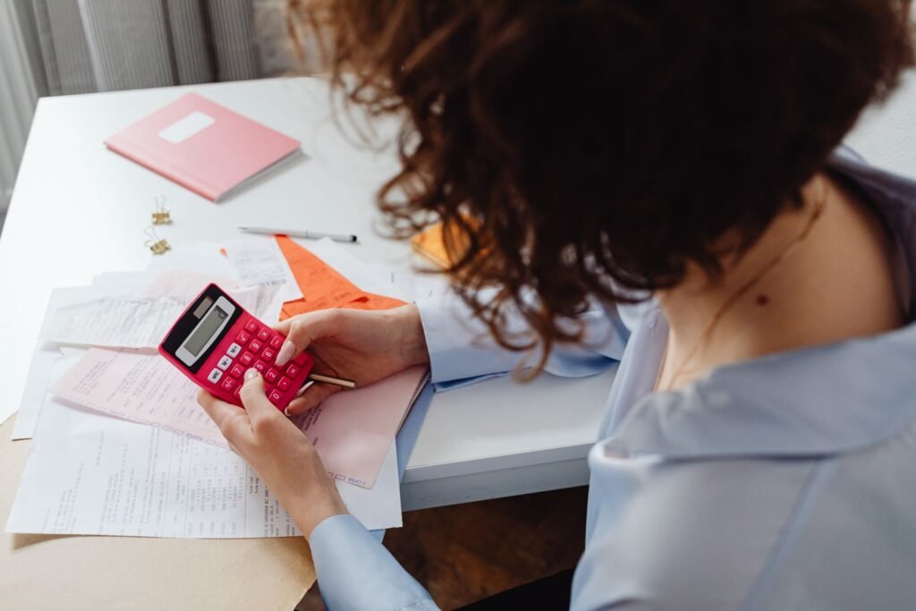 Person planning a budget with documents and a calculator at a desk