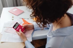 Person planning a budget with documents and a calculator at a desk